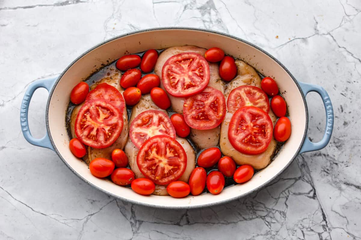 Juicy chicken, melty mozzarella, tomatoes, basil, and balsamic glaze all baked in one pan. Easy, fresh, and so good. Tomatoes added to the pan.