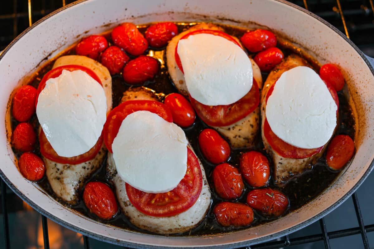 Juicy chicken, melty mozzarella, tomatoes, basil, and balsamic glaze all baked in one pan. Easy, fresh, and so good. Mozzarella added to the top of the tomatoes on the chicken.