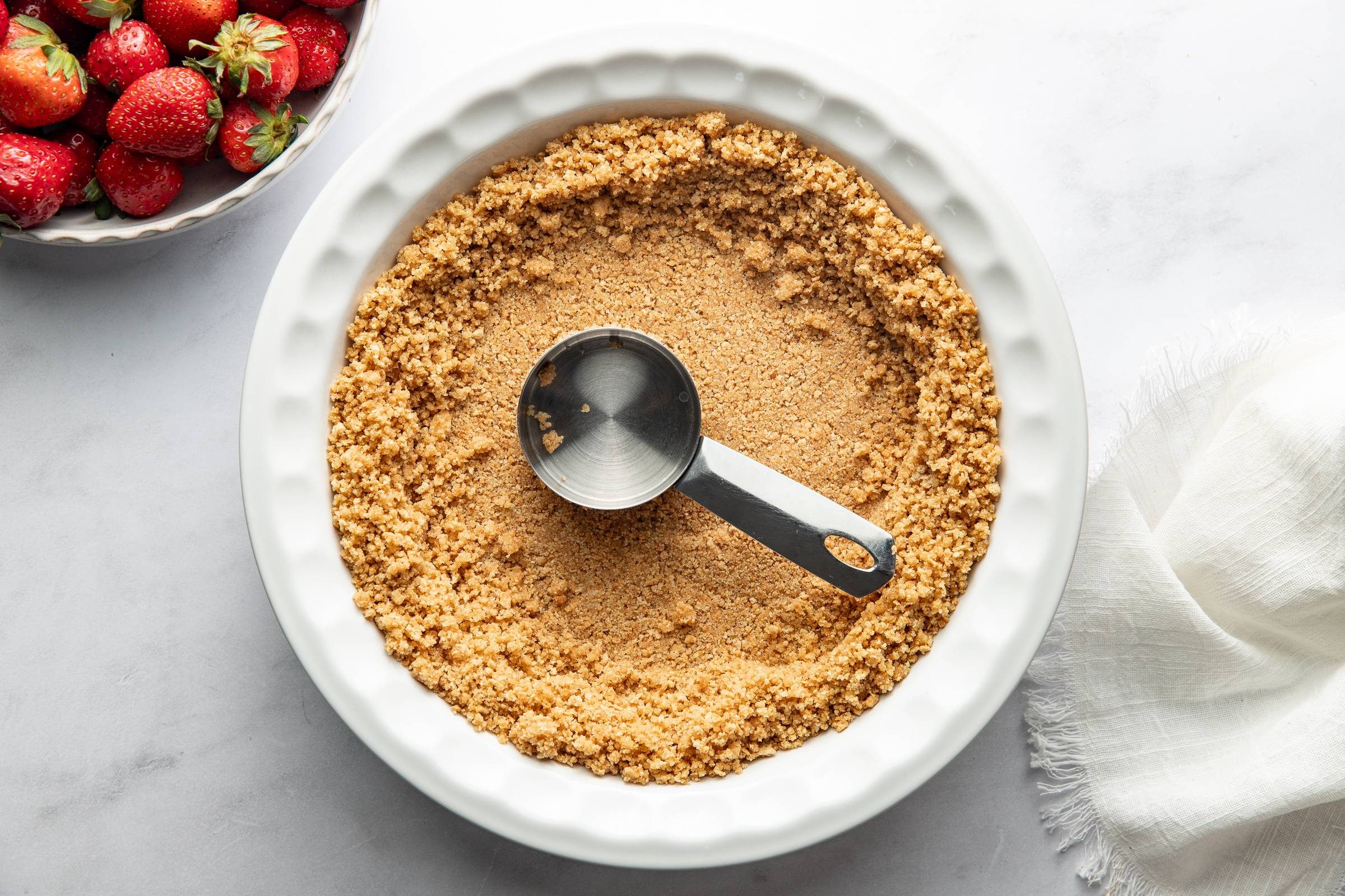 Pressing graham crackers into a crust.