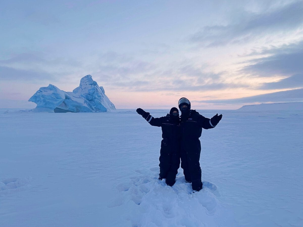northern norway trip - A Guide to Exploring the Outdoors of Northern Norway Eli and Jake from Penguin Trampoline Travel Blog in front of an Iceberg in Svalbard