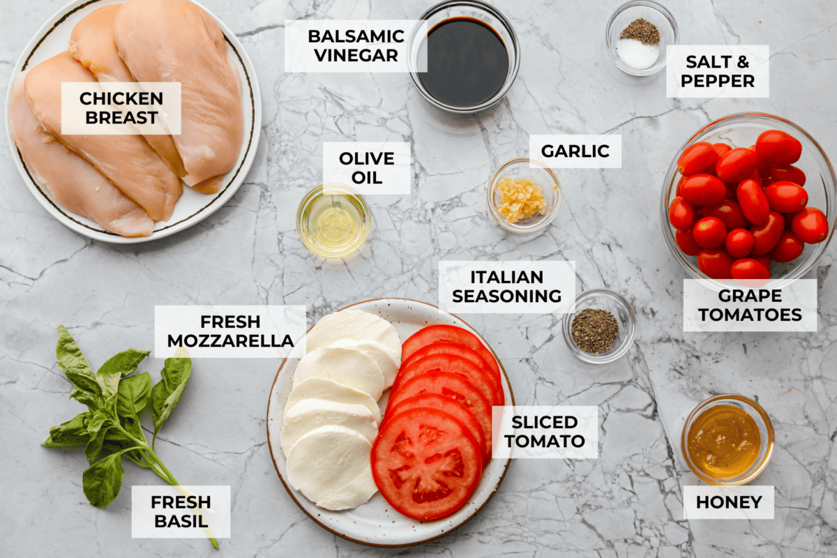 Juicy chicken, melty mozzarella, tomatoes, basil, and balsamic glaze all baked in one pan. Easy, fresh, and so good. Overhead shot of labeled ingredients.