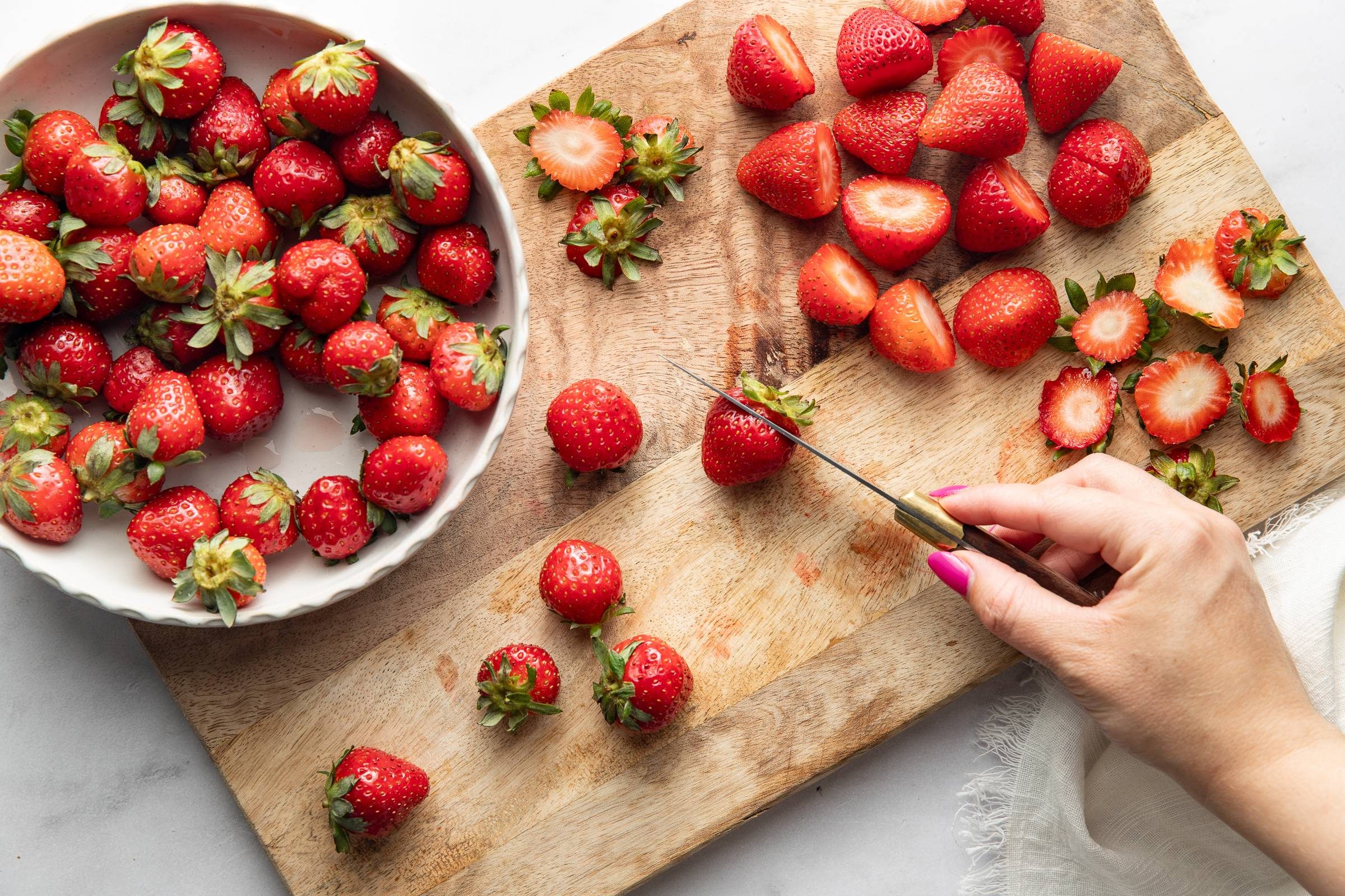 Slicing strawberries on a cutting board.