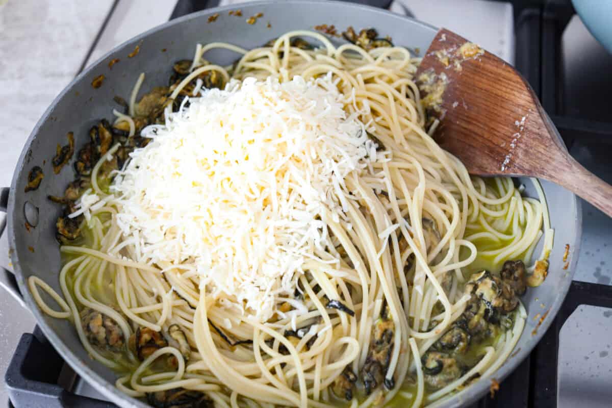 Spaghetti alla Nerano is an unforgettable pasta dish packed with flavor! It has a rich and creamy zucchini sauce infused with garlic, fresh basil, and melted cheese. Seventh photo of the shredded cheeses added to the pasta.