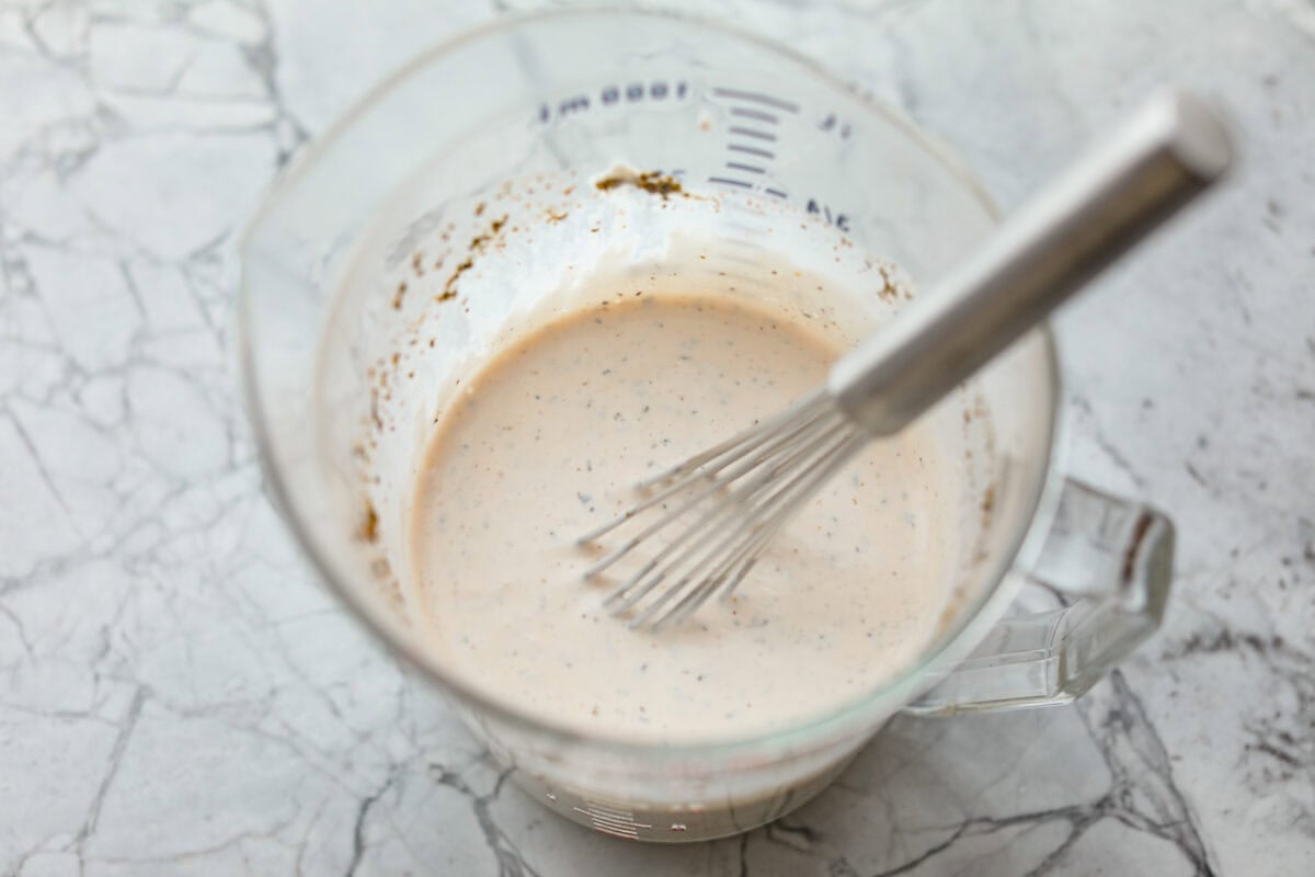 Dressing ingredients all whisked together in a pourable container.