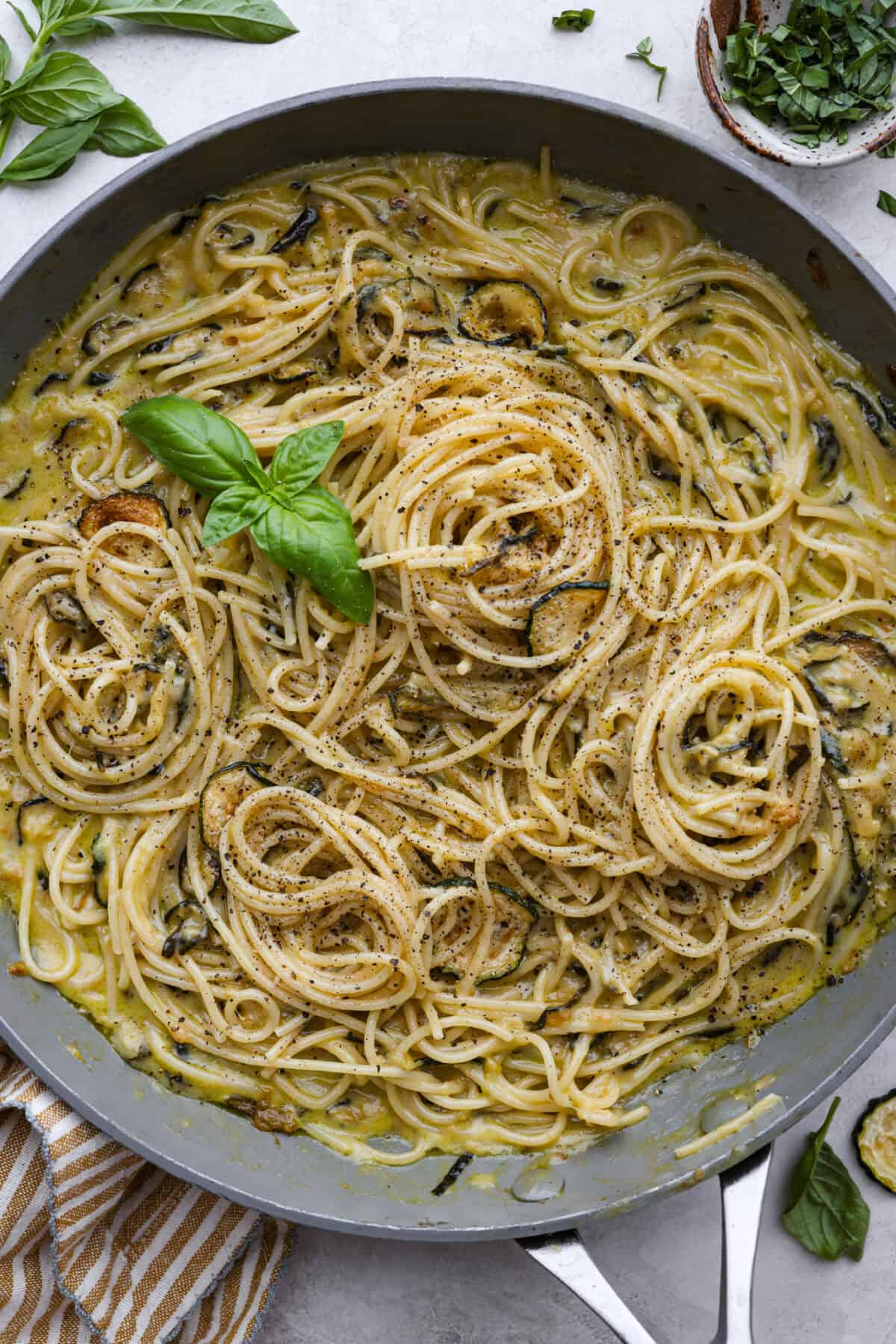 Spaghetti alla Nerano is an unforgettable pasta dish packed with flavor! It has a rich and creamy zucchini sauce infused with garlic, fresh basil, and melted cheese. Top view of the spaghetti alla Nerano in a skillet.