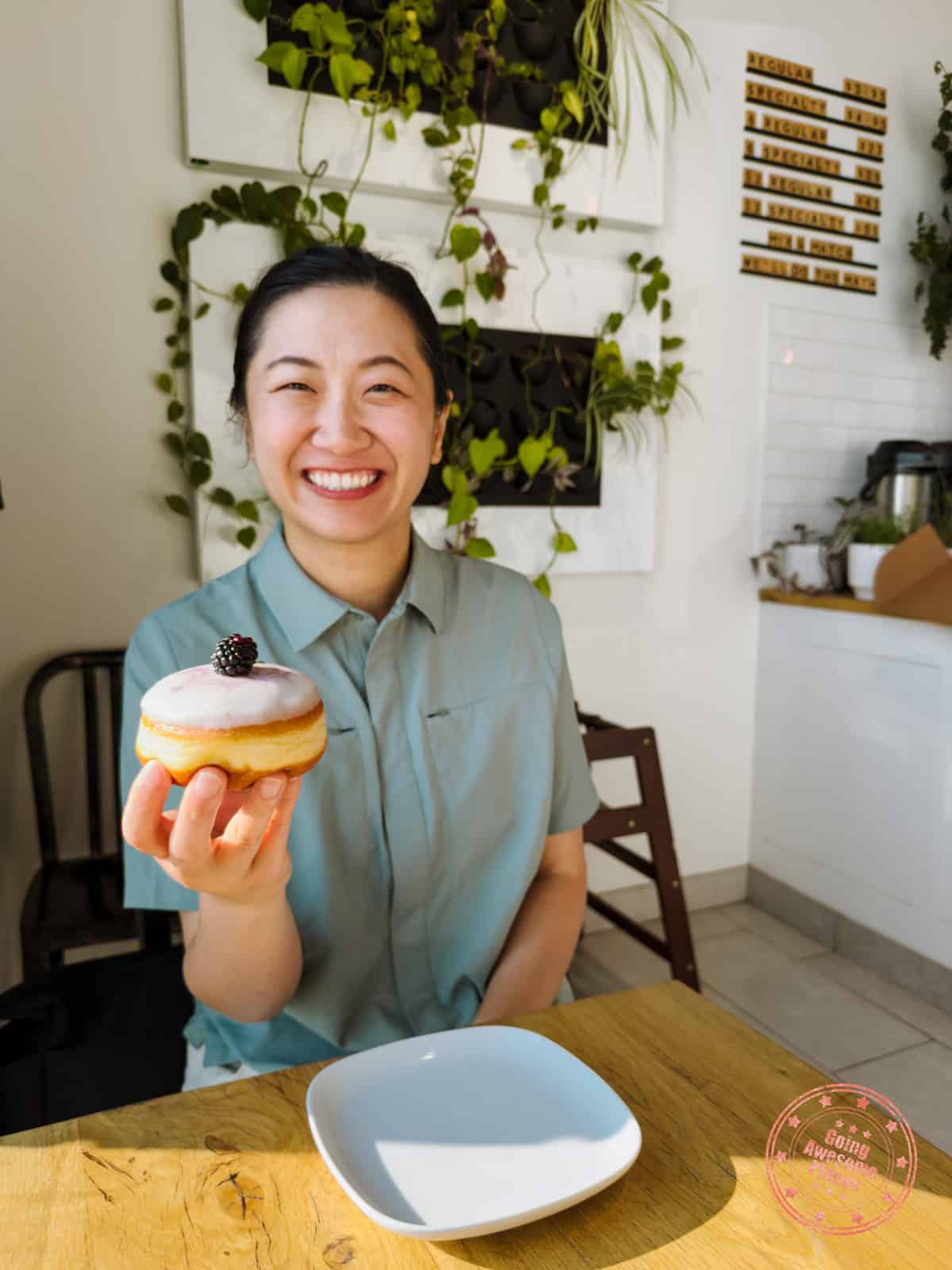 chantelle holding a blackberry lavender cheesecake from oh doughnuts